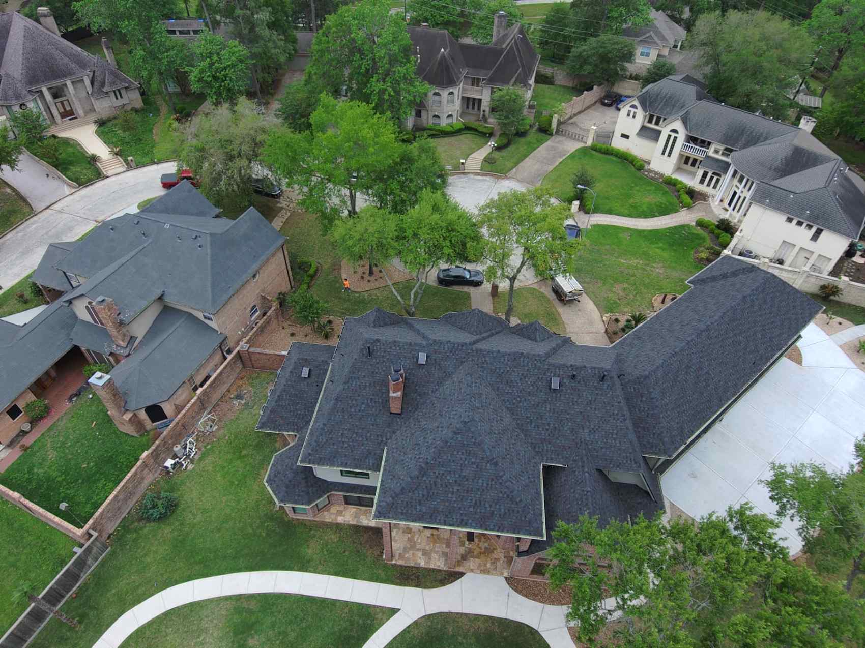 Drone photo of a completed charcoal architectural shingle roof replacement on a large estate home