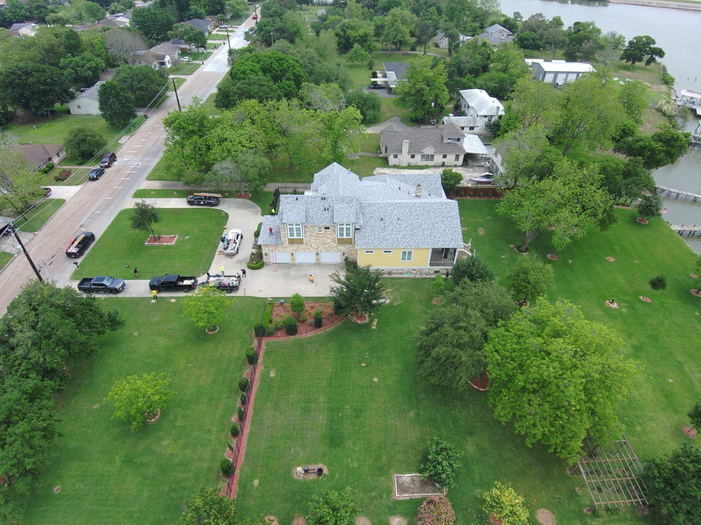 Finished light gray shingle roof on a waterfront estate photographed by drone